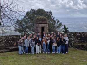 SiPN Spring 2025 students standing together during a field trip to Castelo de Vide, with scenic views in the background.